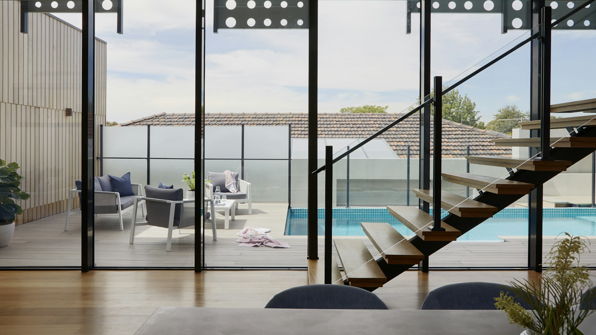 Interior residencial contemporâneo com escada e grandes vãos envidraçados